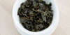 A top-down photo of brewed Tieguanyin tea leaves in a gaiwan.