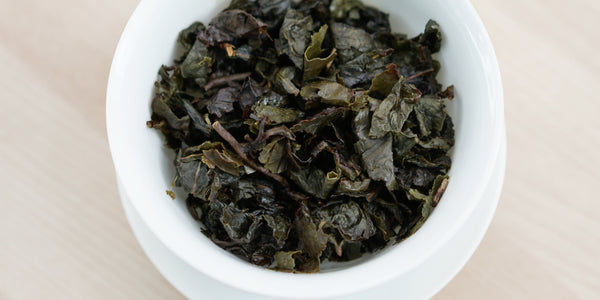 A top-down photo of brewed Tieguanyin tea leaves in a gaiwan.