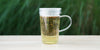 A glass cup with genmaicha brewing in the nested glass infuser.