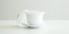 Side view of the gaiwan, with the lid off kilter resting on its side against the bowl.