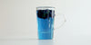 A glass cup with butterfly pea flowers brewing in a nested glass infuser, floating to the top.
