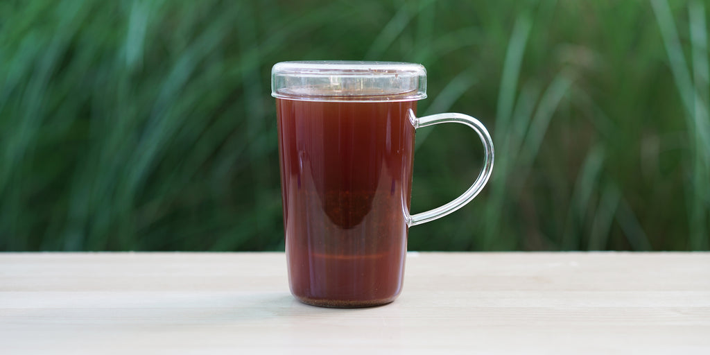 A glass cup with caffeine-free chai brewing in the nested glass infuser.
