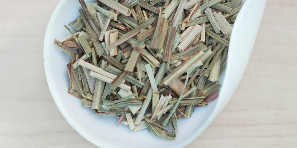 A white dish containing dry lemongrass and ginger.