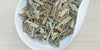 A white dish containing dry lemongrass and ginger.