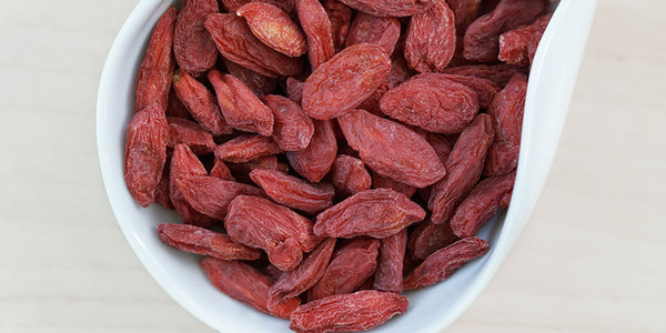 A white dish containing dry goji berries.