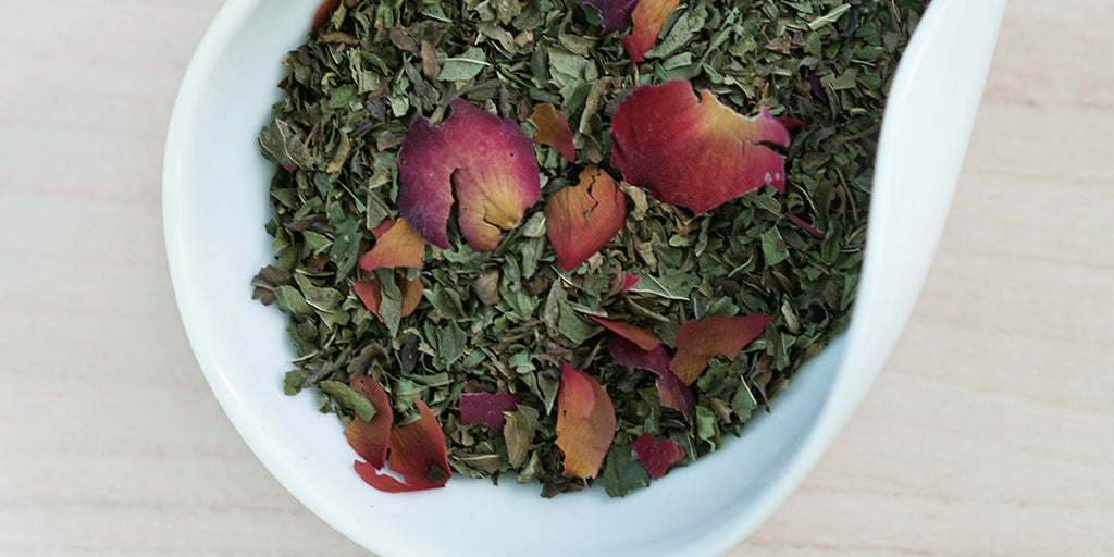 A white dish containing dry peppermint leaves and rose petals.