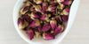 A white dish containing dry rose buds.