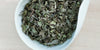 A white dish containing dry wild guava leaves.