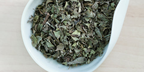 A white dish containing dry wild guava leaves.