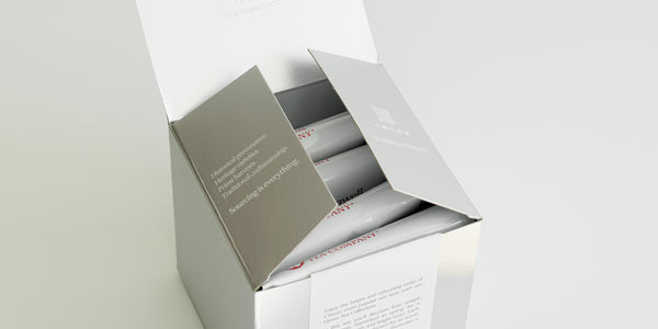 A silver box with 4 white bags of tea inside.