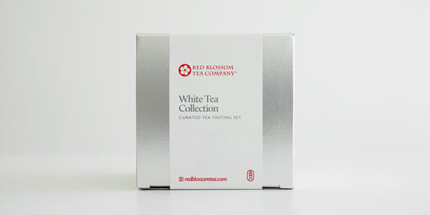 A silver box with a white label reading “White Tea Collection”