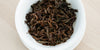 A top-down photo of brewed black tea leaves in a gaiwan.
