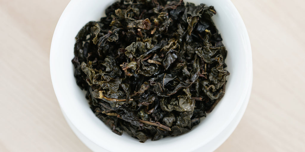 A top-down photo of brewed Formosa oolong tea leaves in a gaiwan.