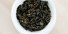 A top-down photo of brewed Formosa oolong tea leaves in a gaiwan.