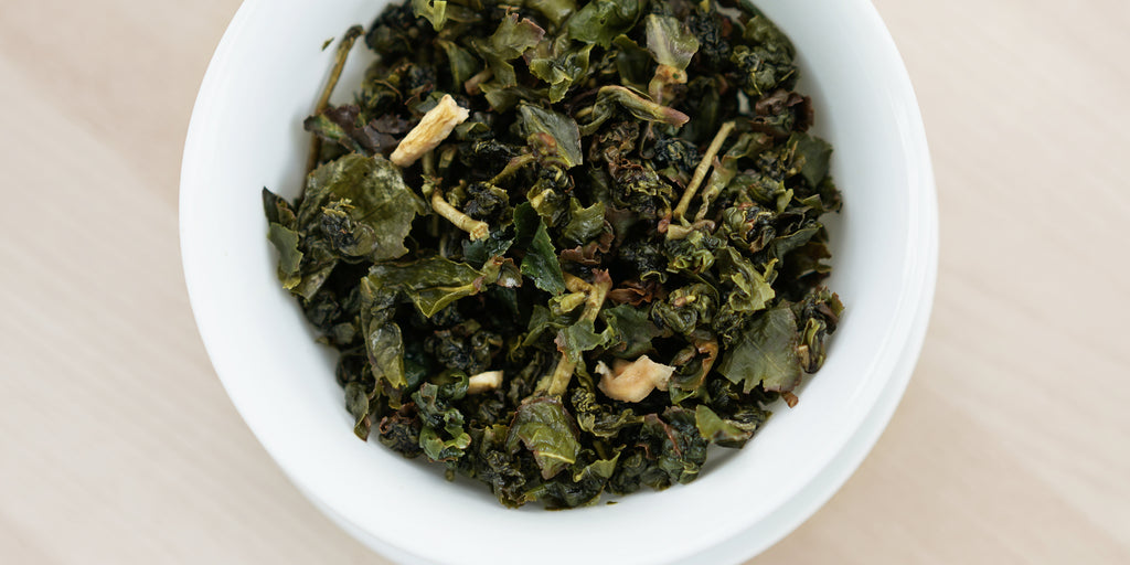 A top-down photo of brewed Formosa oolong tea leaves in a gaiwan.