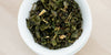 A top-down photo of brewed Formosa oolong tea leaves in a gaiwan.