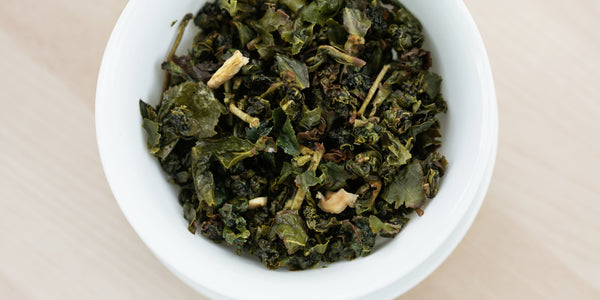 A top-down photo of brewed Formosa oolong tea leaves in a gaiwan.