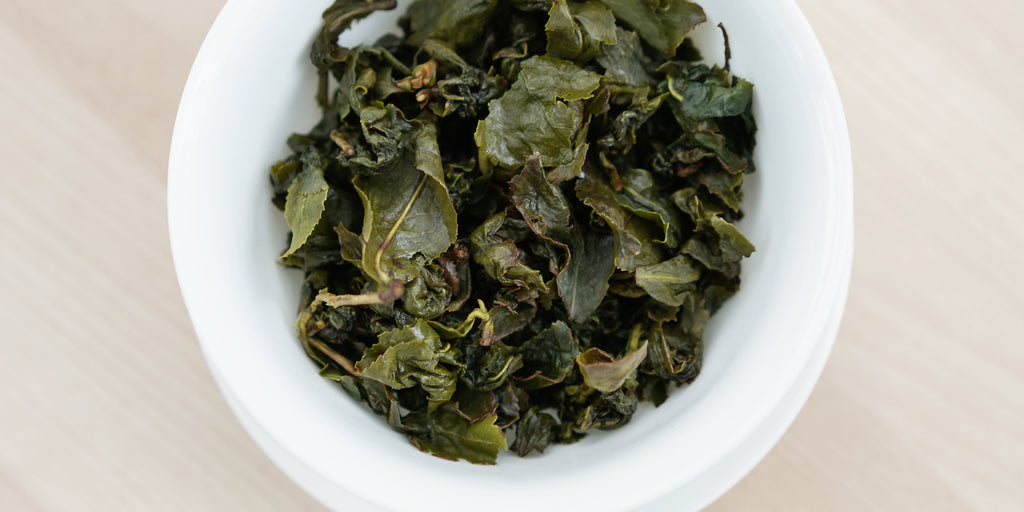 A top-down photo of brewed Formosa oolong tea leaves in a gaiwan.