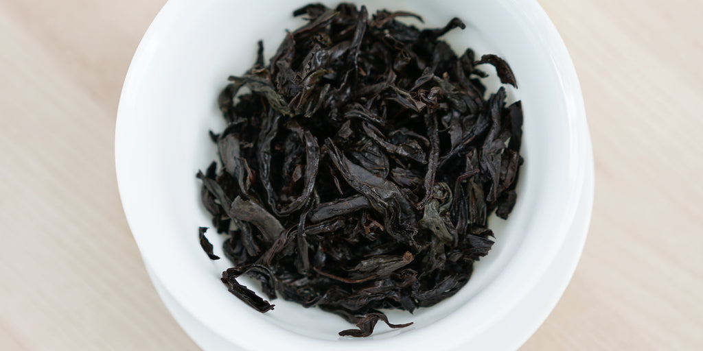 A top-down photo of brewed Wuyi oolong tea leaves in a gaiwan.