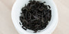 A top-down photo of brewed Wuyi oolong tea leaves in a gaiwan.