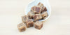 A white dish with cubes of winter melon sugar overflowing from it.